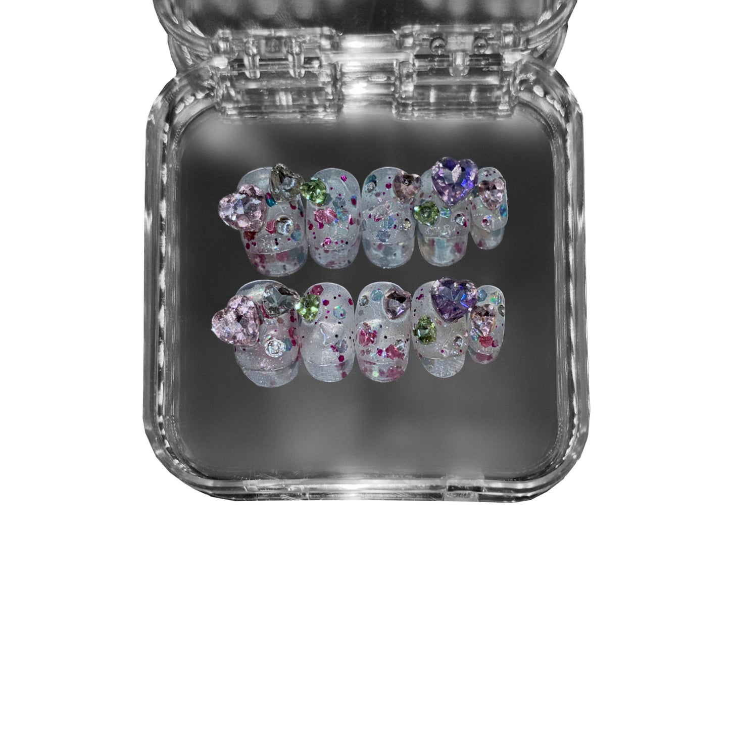 "Gemborn" – a short round press-on nail set featuring a translucent base, sparkling glitter, and 3D gemstone embellishments in dreamy pastel hues.
