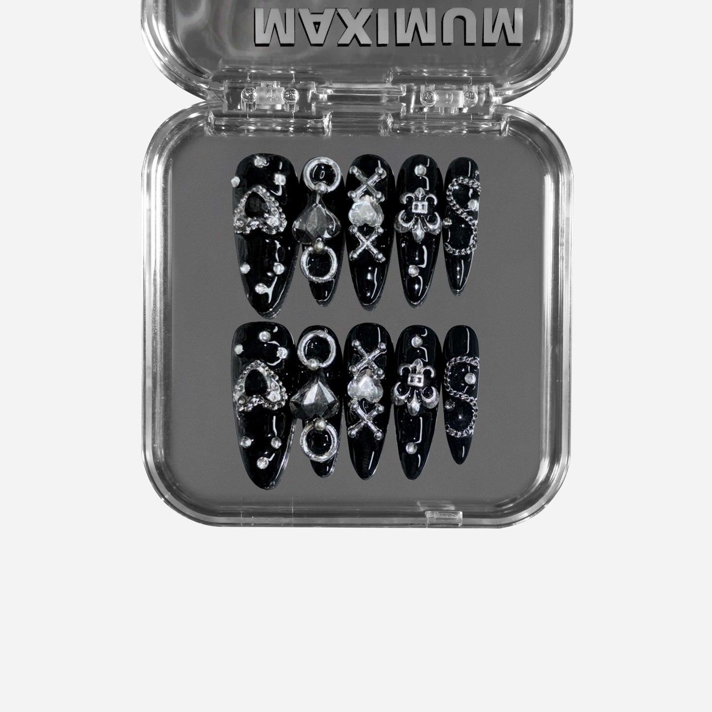 Gutter Saint – a black stiletto press-on nail set featuring punk-inspired chain details, metallic embellishments, and gothic symbols for a rebellious statement look.