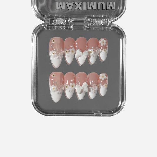 Almond French press-on nails with 3D flowers, bows, and pearl accents in a romantic soft pink design.